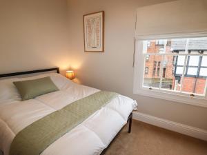 a bedroom with a white bed and a window at 4 Albion Place in Chester