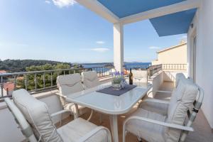 d'un balcon avec une table et des chaises blanches. dans l'établissement Stunning sea view apartment Ani, à Hvar