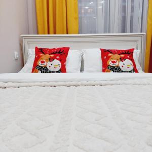 a bed with two hello kitty pillows on it at Аппартаменты рядом с ЭКСПО in Astana