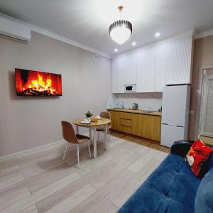 a living room with a table and a kitchen at Аппартаменты рядом с ЭКСПО in Astana