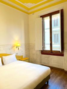 ein Schlafzimmer mit einem großen weißen Bett und einem Fenster in der Unterkunft Hotel Duca D'Aosta in Florenz