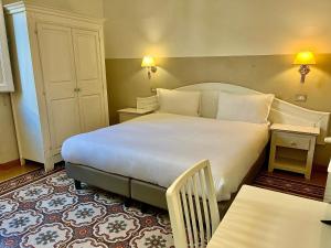 フィレンツェにあるホテル ドゥーカ ダオスタのベッドルーム1室(白い大型ベッド1台付)