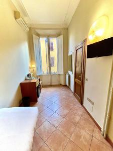 um quarto com uma cama, uma secretária e uma janela em Hotel Duca D'Aosta em Florença
