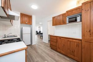een keuken met houten kasten en een witte koelkast bij Apartment 201 - Fremantle studio apartment with ocean and harbour views in Fremantle