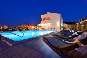 a swimming pool with chairs and a building at night at Vile Dalmacija in Preko