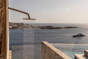 a shower with a view of the ocean and a boat at The Skyvilla Mykonos - A Landmark Property with Breathtaking Views of the Psarou bay in Mikonos