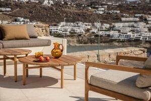 a living room with a table and a couch at The Skyvilla Mykonos - A Landmark Property with Breathtaking Views of the Psarou bay in Mikonos