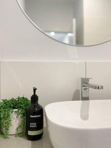 - une salle de bains avec une bouteille de savon noire à côté d'un lavabo dans l'établissement 83 Appin - Newly renovated house, à Wangaratta