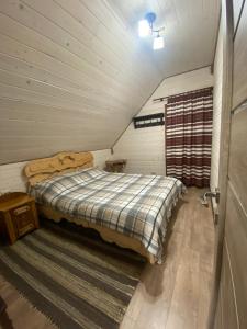 ein Schlafzimmer mit einem Bett im Dachgeschoss in der Unterkunft ЕКО-котедж in Werchowyna