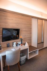 a room with a desk and a tv on a wall at Hotel am Schlossberg in Herrenberg