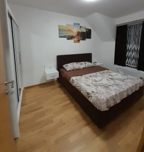 1 dormitorio con 1 cama y suelo de madera en KONAK ViLA MIRKOVIĆ, en Soko Banja