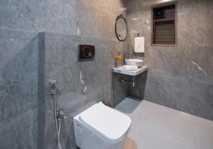 un baño con inodoro y lavabo en SaffronStays Peshwaai, en Karjat