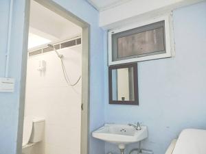La salle de bains blanche est pourvue d'un lavabo et d'un miroir. dans l'établissement wonderful hostel khaosan, à Bangkok