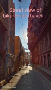 a person riding a scooter down a city street at Karina art Home stay in Bikaner