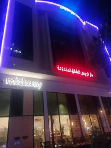 a building with a lit up sign on top of it at Dar Al Riyadh Apartments in Riyadh