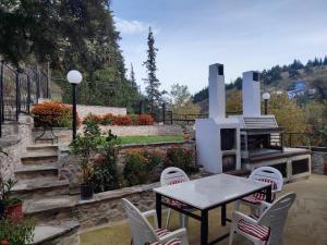 a patio with a table and chairs and a fireplace at Elassona Comfort Home in Elassona