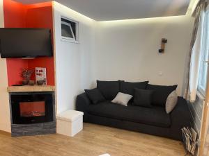 a living room with a black couch and a fireplace at Orreska 4 à 6 pers centre station in Les Orres