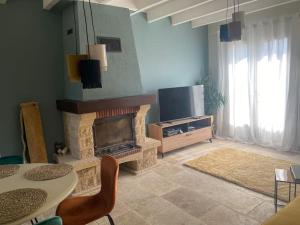 ein Wohnzimmer mit einem Kamin und einem TV in der Unterkunft Beautiful two bedroomed gite in Soturac