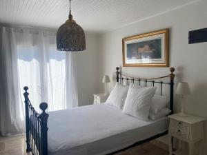 - une chambre dotée d'un lit avec des draps blancs et un lustre dans l'établissement Beautiful two bedroomed gite, à Soturac