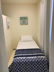 een kleine slaapkamer met een bed in een kamer bij Beachside Apartment 1 with plunge pool in Port Douglas