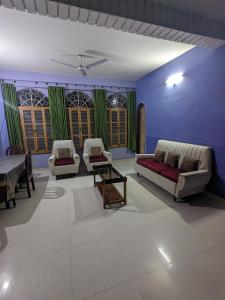 a living room with a couch and chairs and a table at Saikia Nest the Home-stay in Guwahati