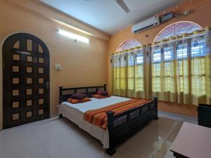 a bedroom with a bed and two windows at Saikia Nest the Home-stay in Guwahati