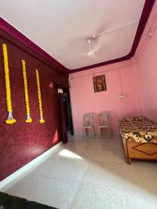 een kamer met roze muren en stoelen en een tafel bij Swapnapurti Luxurious stay kashid beach alibaugh in Revadanda