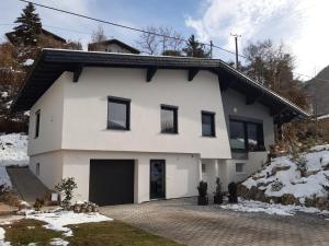 a white house with black windows and a driveway at Your BaseCamp! in Roppen