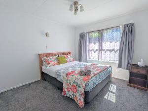 a bedroom with a bed and a window at Springfield Bliss in Rotorua