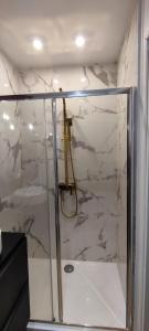 a bathroom with a shower with white marble at Nuit d'évasion love room avec baignoire balnéothérapie in Toulon