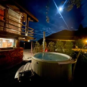 eine Whirlpool-Badewanne auf einer Terrasse in der Nacht in der Unterkunft Mazot Agora Suite - Pop-Up Gallery Experience Suite in Salvan