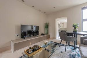 a living room with a large tv on the wall at Elegant 1-BR Retreat in Ilford Centre in Ilford