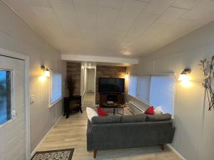 ein Wohnzimmer mit einem Sofa und einem Flachbild-TV in der Unterkunft Cozy Guest House in Bellingham