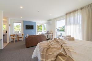 a bedroom with a large bed and a living room at The Mayflower Cottage in Te Anau