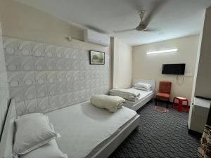 a room with two beds and a tv in it at Hotel In Need - Near to the US France Italy Saudi Embassy and Airport in Dhaka +105 photos