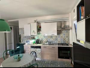 a kitchen with a table and a kitchen with white cabinets at Lake Apartment Ischia Green in Tenna 