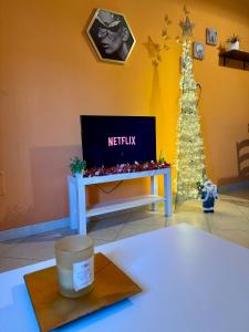 a tv sitting on a table in a room with a christmas tree at ButterflyHouse in Monserrato