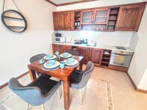 uma pequena cozinha com uma mesa de madeira e cadeiras em Private 1bedroom apartment in SPA Resort em Bansko
