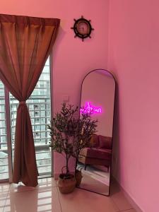 a pink room with a mirror and a chair at Nawwarah Homes @ Southville City (WiFi + NETFLIX) in Kajang