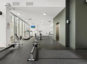 a gym with treadmills and machines in a building at Luxury City Center King Bed Apartment and Study in Brisbane