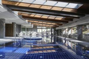 a swimming pool with blue tiles in a building at Private 1bedroom apartment in SPA Resort in Bansko