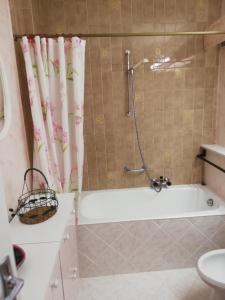 a bathroom with a bath tub with a shower curtain at Residence adret in Auron +11 photos