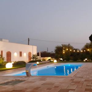- une piscine en face d'une maison la nuit dans l'établissement CASA VACANZA DONNA LINA, à Conversano