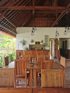 een eetkamer met een houten tafel en stoelen bij Maharatu Villa Lembongan in Nusa Lembongan