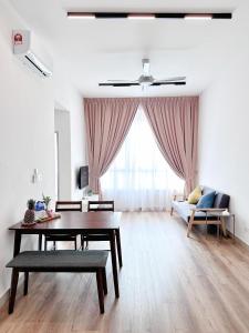 - un salon avec une table et un canapé dans l'établissement Amber Cove by C Homestay Malacca, à Malacca