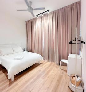 - une chambre avec un lit blanc et un ventilateur de plafond dans l'établissement Amber Cove by C Homestay Malacca, à Malacca