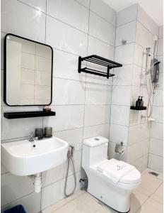 La salle de bains blanche est pourvue d'un lavabo et de toilettes. dans l'établissement Amber Cove by C Homestay Malacca, à Malacca