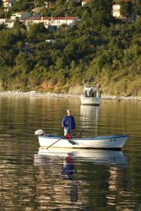 a man is rowing a boat in the water at Eola Leisure Rooms in Stara Baška