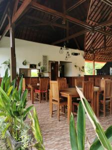 uma sala de jantar com mesas e cadeiras de madeira em Maharatu Villa Lembongan em Nusa Lembongan