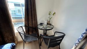 een tafel en 2 stoelen in een kamer met een raam bij ไนซ์สเตย์ เฮาส์ แอทคลองสาม รังสิต คลองหลวง ปทุมธานี Nice Stay House at Khlong Sam - Rangsit - Khlong Luang - Phathumthani in Ban Talat Rangsit